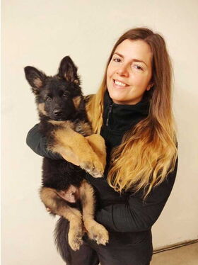 Mathilda Romin med en schäfer valp i famnen