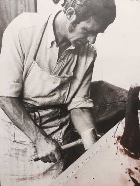 Gunnar Romin som startade företaget Almtuna Tapetserarverkstad på jobbet med en trädhammare i handen